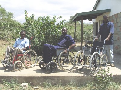 Patrick (centre) in the original 6-wheel model: Daniel Kangogo (on L) in one of their early replicas; Fundi (R) with one of the 4-wheeler, pushed type..
